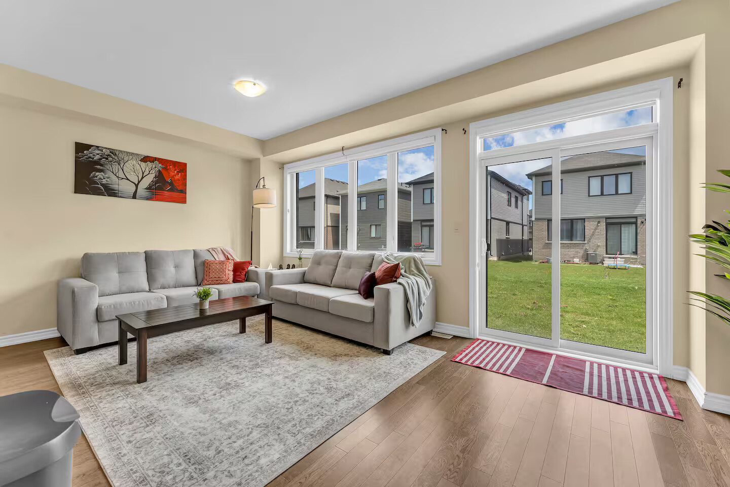 Bright living room with sectional seating and garden-facing patio doors